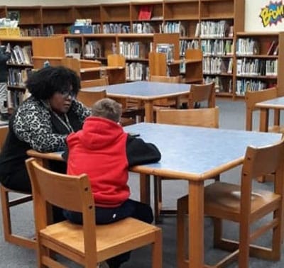 Woman helping a child read